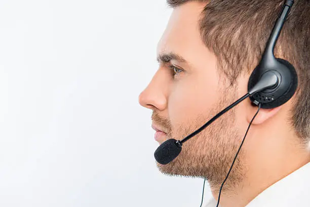 A close-up side-face portrait of a young agent of call centre