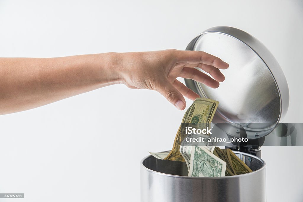throwing away dollar in trashcan Currency Stock Photo