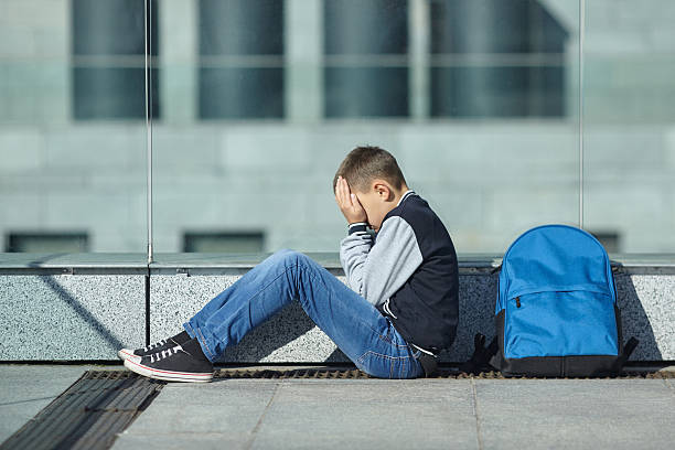 istock schoolboy crying on the street 617898260