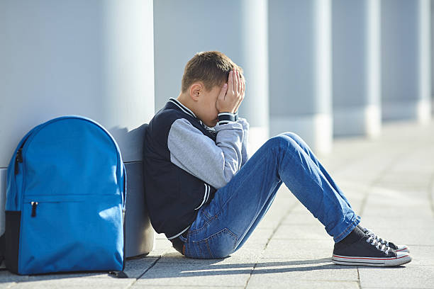 istock schoolboy crying on the street 617898282