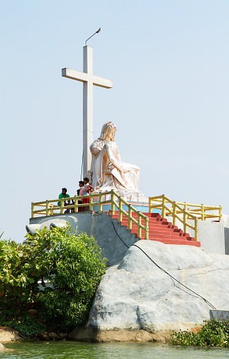 Kerala Backwaters, India - January 22, 2012: The christian cross and Lamentation of Christ monument on the small rock island in Kerala Backwaters, southern India