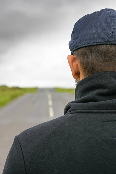 Man looks at an empty road stock photo