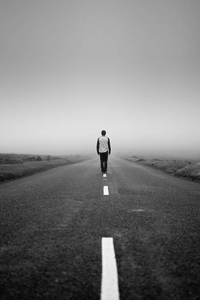 Man stands in the middle of a road stock photo