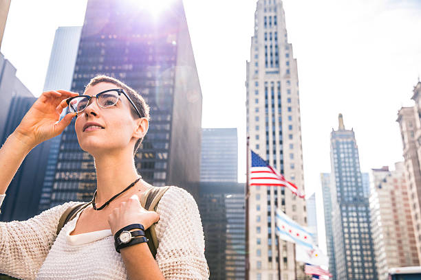 istock Young woman in downtown Chicago against US flag 617899112