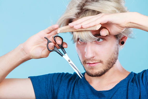 istock Man with scissors and comb creating new coiffure 617900334
