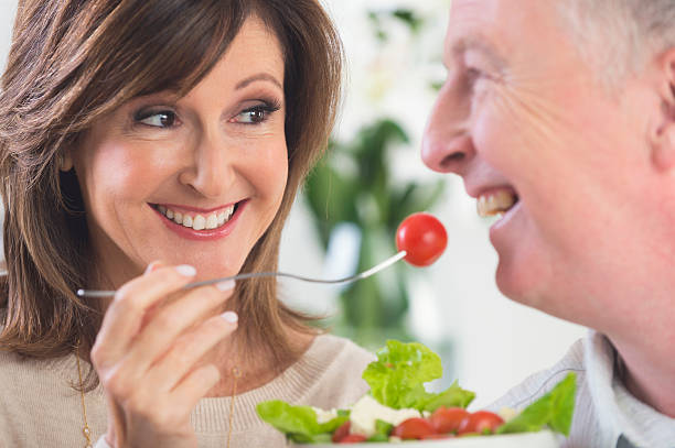 istock Mature woman feeding man salad 617901444