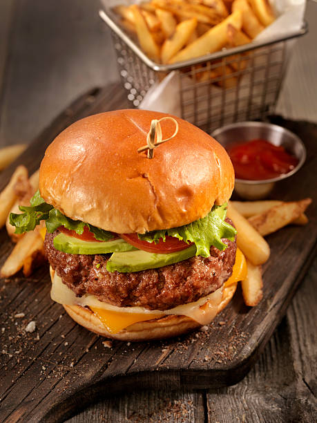 hamburguesa con queso de aguacate con una cesta de papas fritas - hamburger burger symmetry cheeseburger fotografías e imágenes de stock