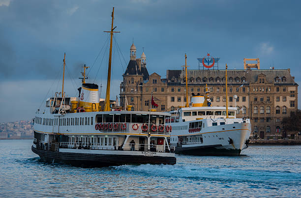 Istanbul, Turkey - October 24, 2016: Two passenger ferries are seen in the photo. Photo is taken at the Kadıköy port of Istanbul. One of the ferries is departing while the other one is arriving to Kadıköy. On the background, the historical Haydarpaşa railway station is seen. These kind of passenger ferries are called \