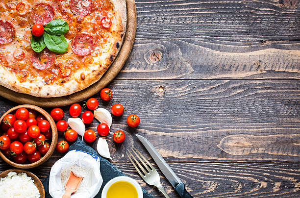 istock Hot Italian pizza on a rustic wooden table. 617905156