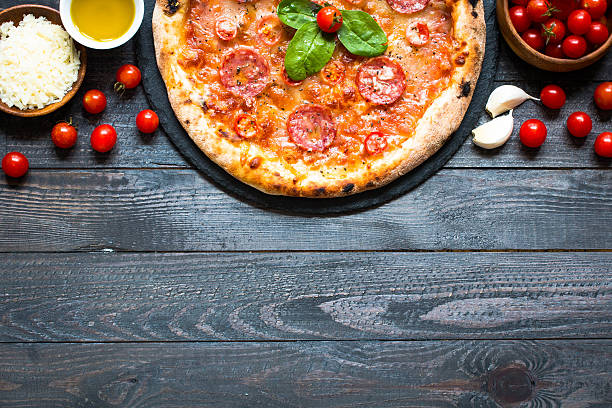 istock Hot Italian pizza on a rustic wooden table. 617905494