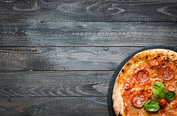 istock Hot Italian pizza on a rustic wooden table. 617905652