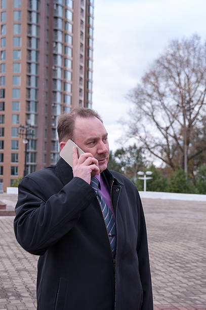 istock Businessman talking on phone next to the new building 617909746