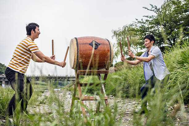 männer spielen japanische taiko-trommel im freien - taiko drum stock-fotos und bilder