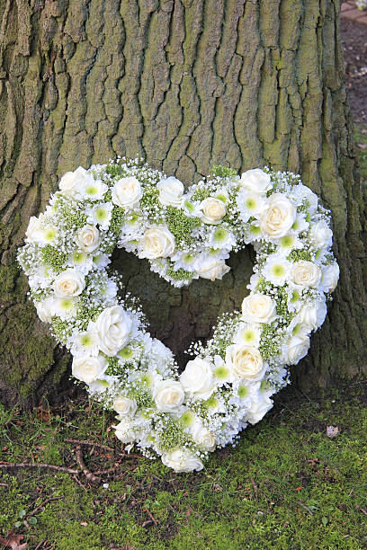 istock Heart shaped sympathy arrangement near a tree 618023138