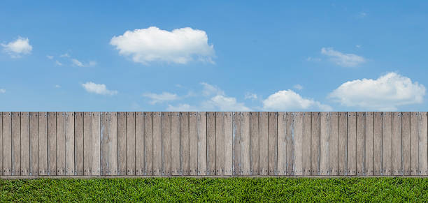 istock wooden fence with green on blue sky 618024950