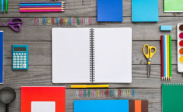istock Open notebook with school supplies on the wooden table 618027628