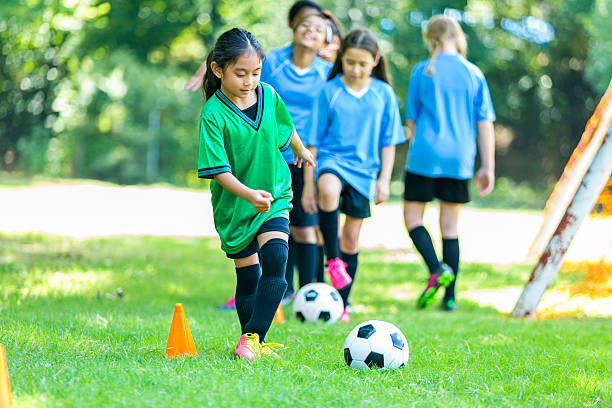 młoda zawodniczka ćwiczy ćwiczenia - playing field kids soccer goalie soccer player zdjęcia i obrazy z banku zdjęć