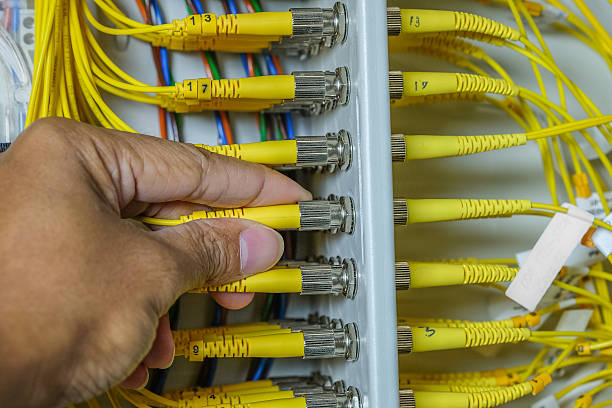 istock hand of system administrator and fiber optic cables 618032794