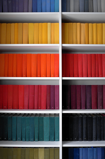 Colourful books on a bookshelf. A rainbow of book covers.