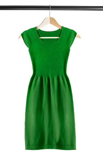 Green knitted dress on clothes rack isolated over white