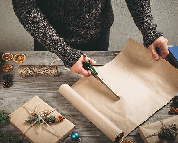 istock Man is preparing a Christmas gift on wooden table 618036406