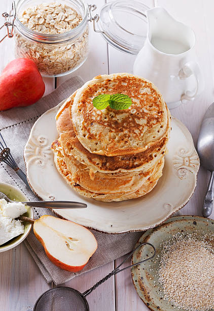 Oatmeal pancakes over white wooden background stock photo