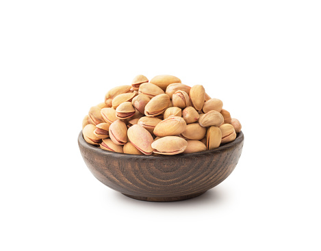 Pistachios with wooden bowl , isolated on white