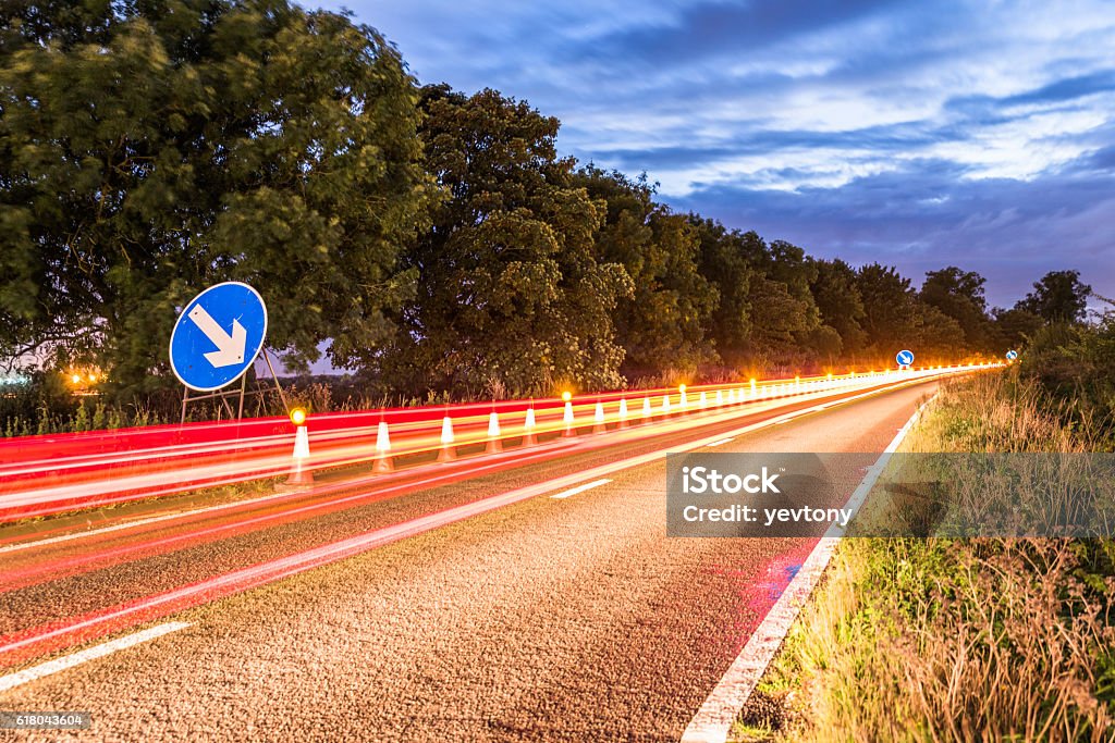 Authentiques travaux routiers autoroutiers britanniques Avertissement cônes de circulation la nuit - Photo de Nuit libre de droits