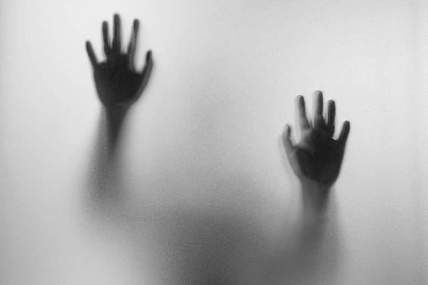 Shadow hands of the Man behind frosted glass. Shadow hands of the Man behind frosted glass.Blurry hand abstraction.Halloween background.Black and white picture murderer photos stock pictures, royalty-free photos & images
