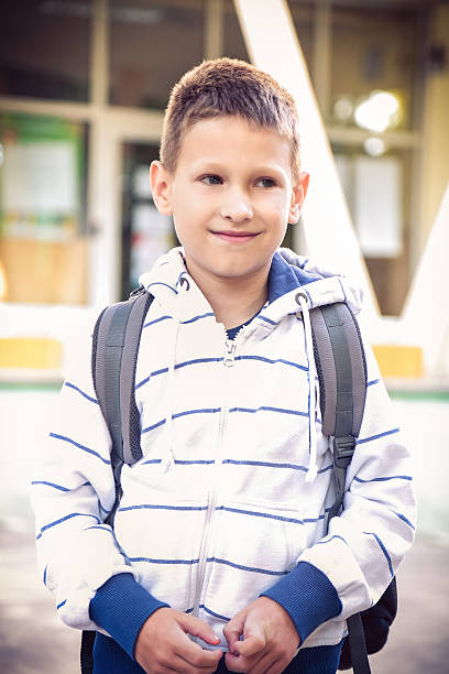 istock Little 7 years Schoolboy in front of the school 618043686