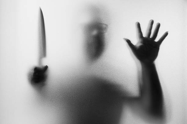 istock Dangerous man behind the frosted glass with a knife 618045204