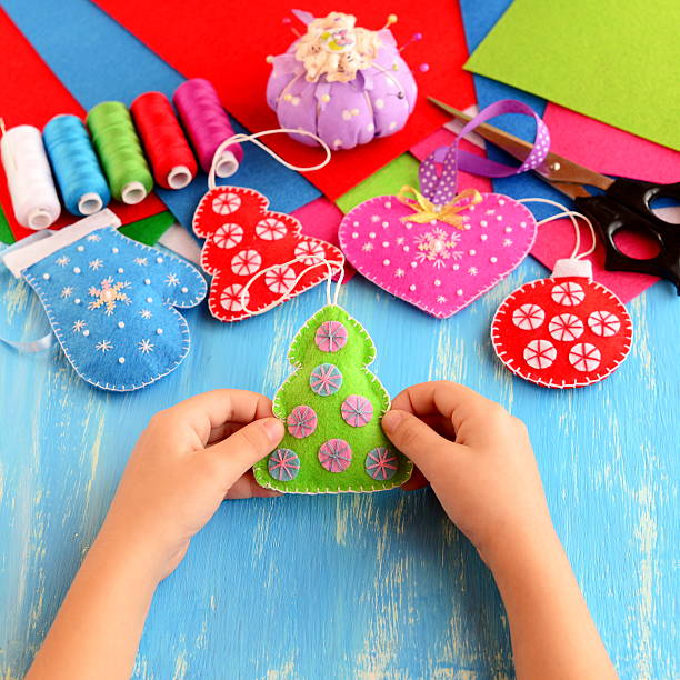 istock Small child holds felt Christmas tree decor in his hands 618047112