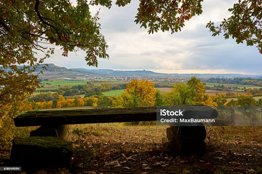 Fall in Franconia A wooden bench in front of the wonderful landscape over Bad Staffelstein, Franconia, Bavaria, Germany in autumn. Bad Staffelstein Stock Photo