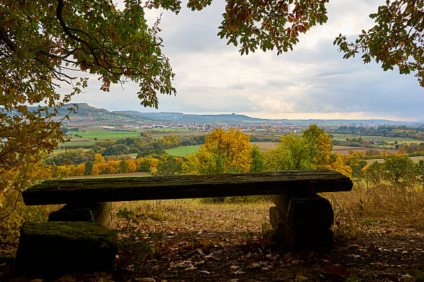 Fall in Franconia A wooden bench in front of the wonderful landscape over Bad Staffelstein, Franconia, Bavaria, Germany in autumn. bad staffelstein stock pictures, royalty-free photos & images