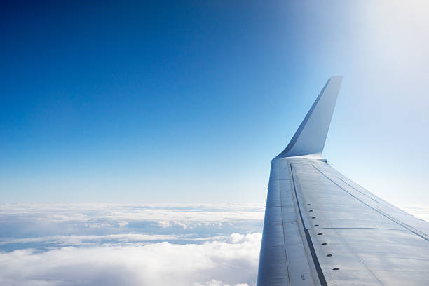 ala di aeroplano volare sopra le nuvole - wing airplane window sunset foto e immagini stock