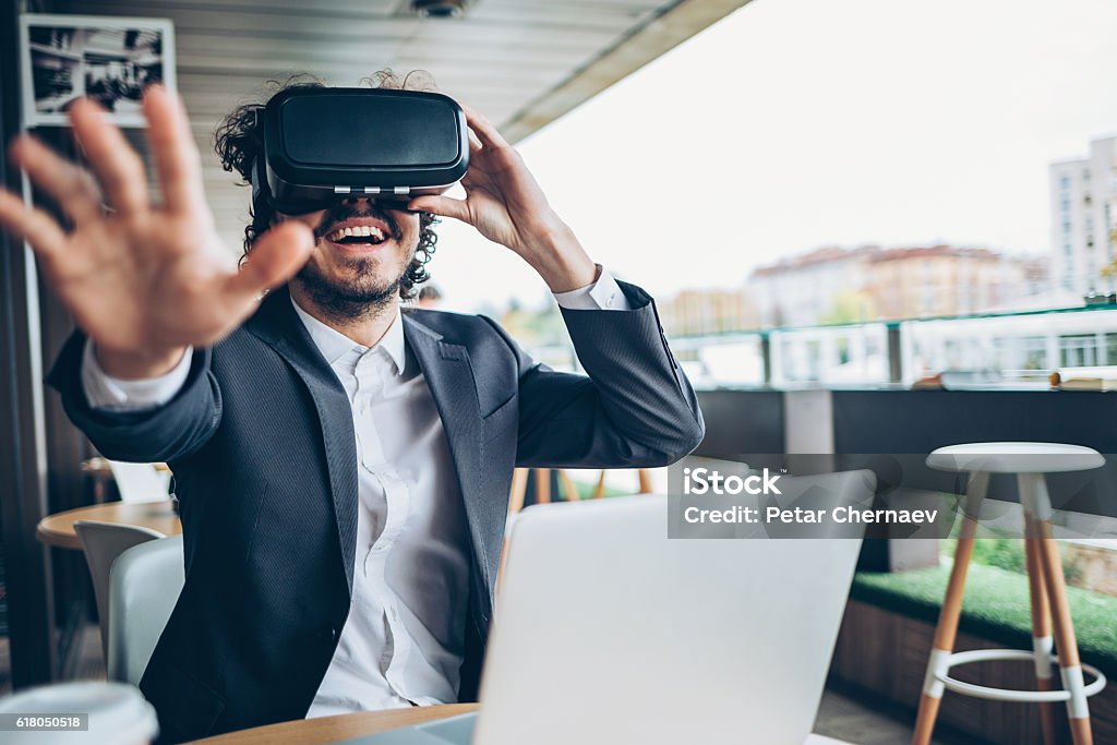 Jeune homme regardant à travers une réalité virtuelle et gesticulant - Photo de Réalité virtuelle libre de droits