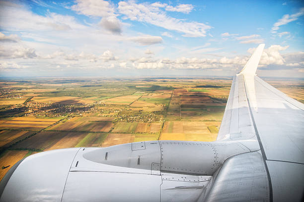 airplane wing flying above the fields in hungary - wing airplane window sunset imagens e fotografias de stock