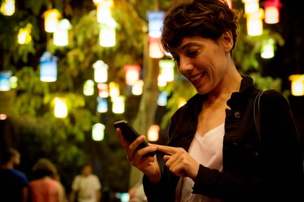 istock young woman looks into smartphone at night 618053114