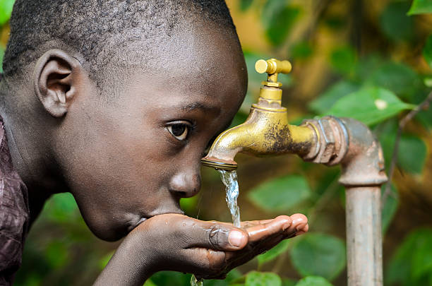 istock Water is Life! African Baby Boy Drinking Water (Drought Symbol) 618053562