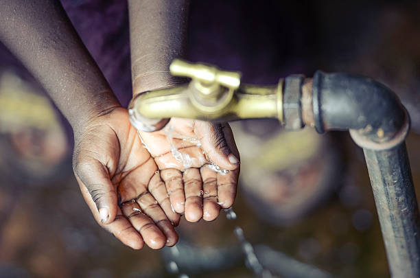 istock African Child with Hands Cupped under Water Tap in Bamako 618055512