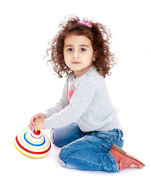 istock Little girl spinning a dreidel 618055896