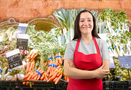 Portrait of a happy woman working at a supermarket and looking at the camera smiling