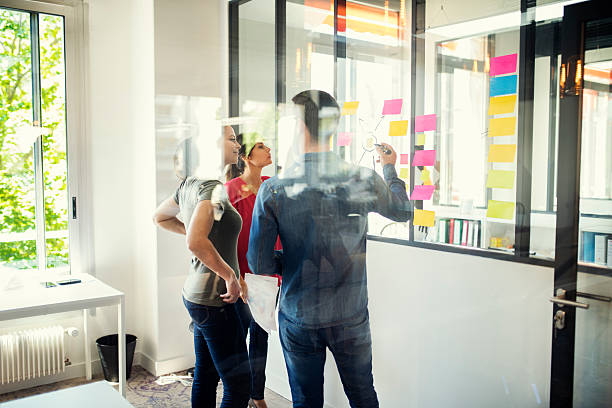 istock Creative designers discusing in front of glass wall. Startup office 618057950