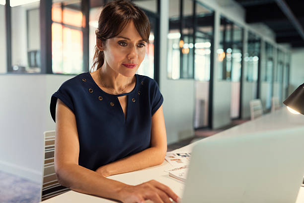 istock Concentrated middle aged woman focused on her laptop screen 618058958