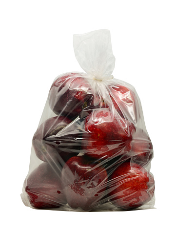 Red apples in plastic bag isolated on white with clipping path