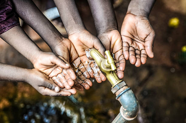 istock Lots of African Hands Cupped under Water Tap in Mali 618060178