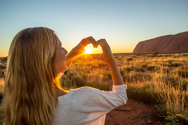 istock View of female framing sunset into heart shape 618060650