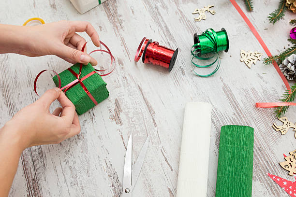 istock Hands of woman decorating Christmas gift box 618061060