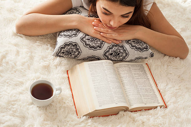 istock Young woman reading book on carpet 618061650