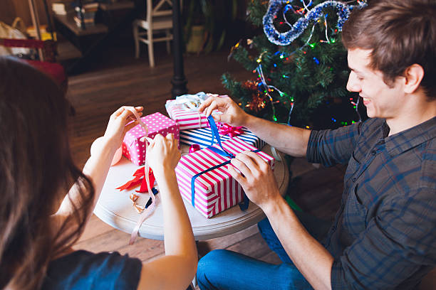 istock Smiling man packing presents with wife 618063844